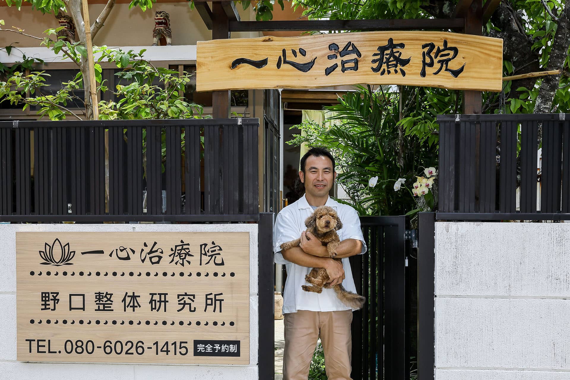 一心治療院外観と犬を抱っこする施術者